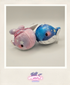 Two plush toy whales, one pink and one blue with star patterns, on a light gray background.